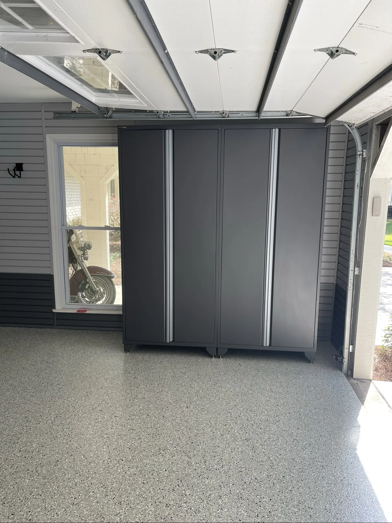 Epoxy flake garage floor with dark metal cabinets