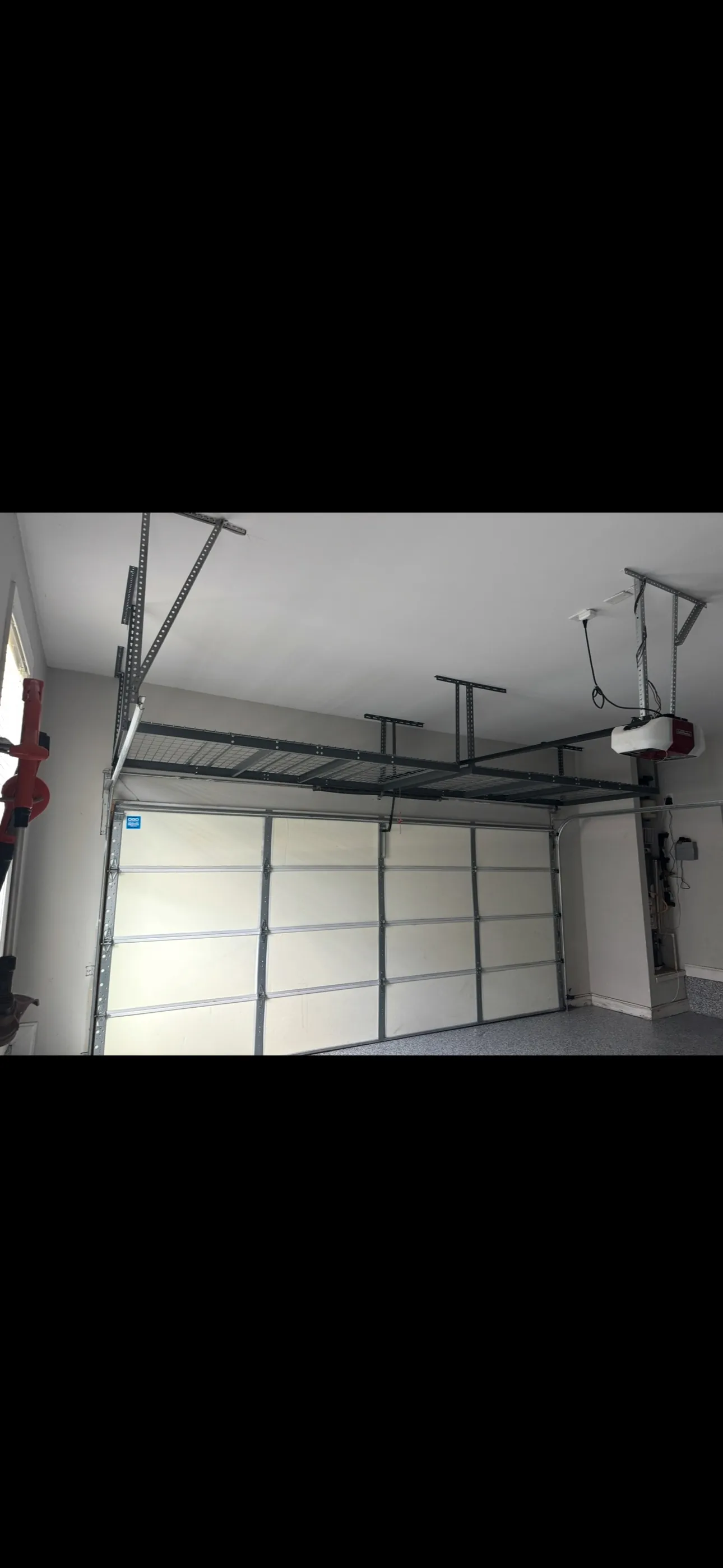 Overhead storage rack mounted above a garage door
